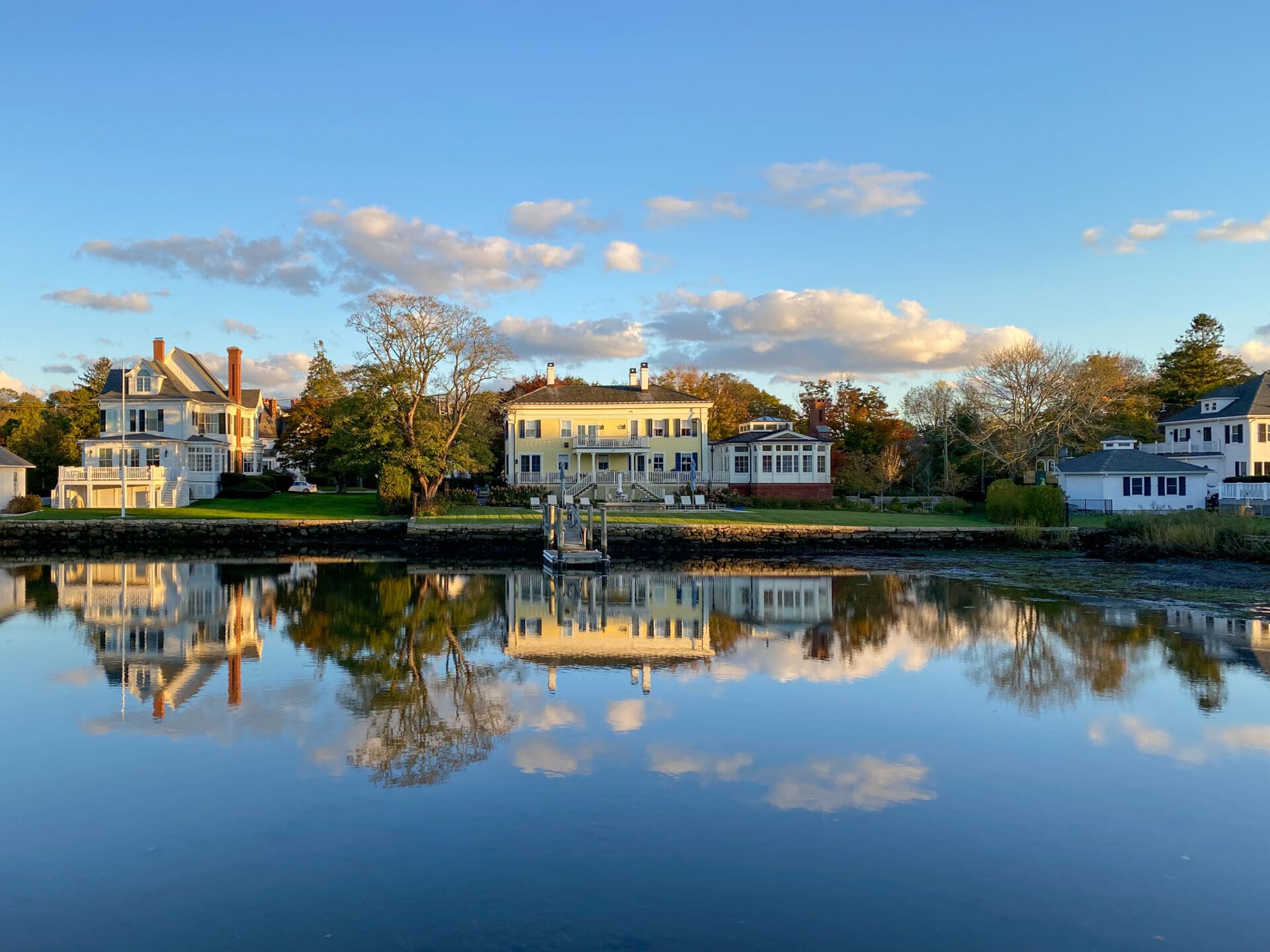 Houses reflected in calm water.