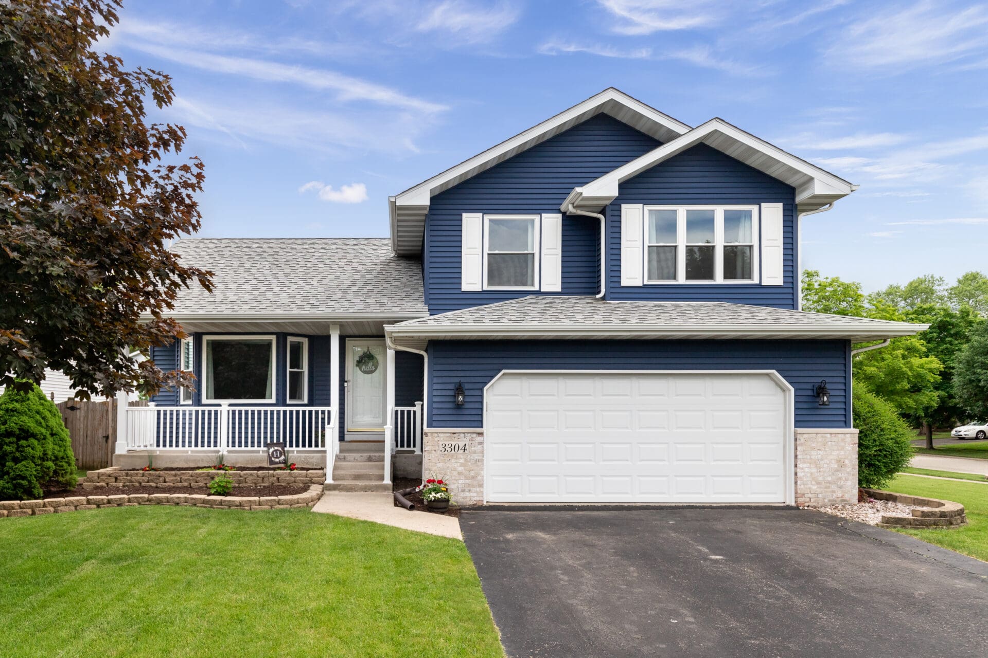 Blue two-story house with white garage.