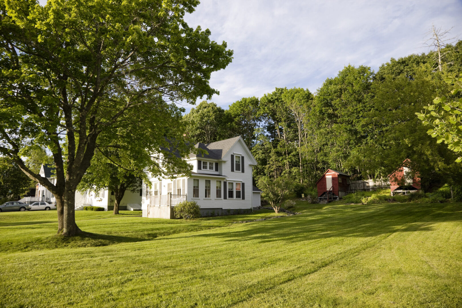 White farmhouse on a green lawn.